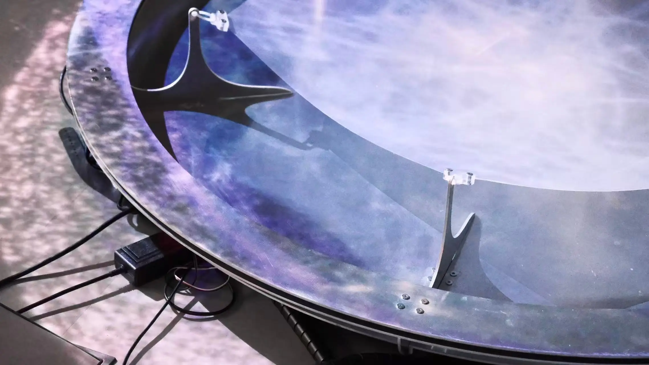 Fabric membrane rippling inside a circular aluminium frame under projection