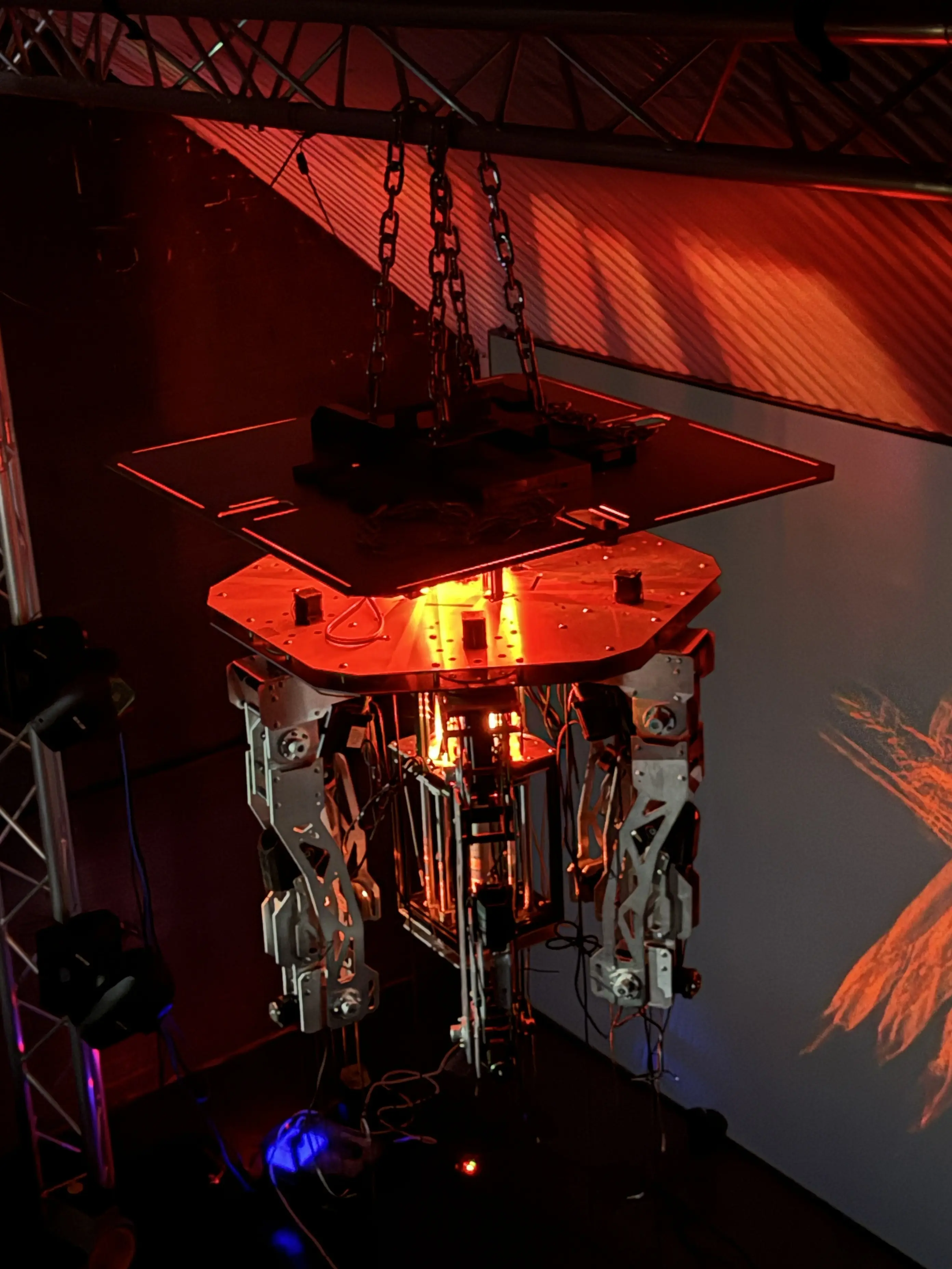 The machine suspended before a projection wall
